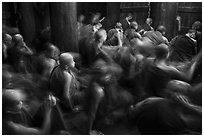 Monks in motion during prayer. Mandalay, Myanmar ( black and white)