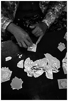 Close-up of hands separating gold leaves. Mandalay, Myanmar ( black and white)