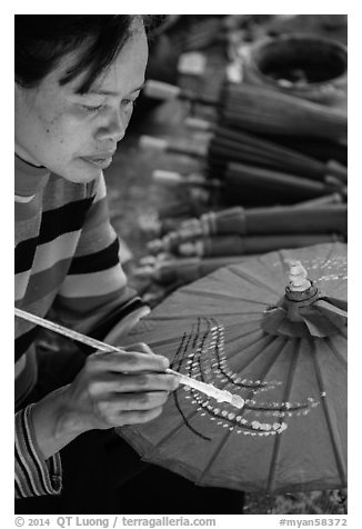Woman painting the paper sun umbrellas carried by the monks. Pindaya, Myanmar (black and white)
