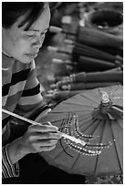 Woman painting the paper sun umbrellas carried by the monks. Pindaya, Myanmar ( black and white)