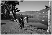 Man carrying baskets on road near Pone Tanoke Lake. Pindaya, Myanmar ( black and white)