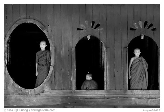 Buddhist monks looking through windows of Shweyanpyay Monastery, Nyaung Shwe. Inle Lake, Myanmar (black and white)