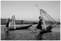 Intha fishermen row with leg and hold conical baskets. Inle Lake, Myanmar ( black and white)