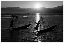 Intha fishermen row with leg with setting sun. Inle Lake, Myanmar ( black and white)