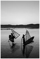 Intha fishermen lifting conical basket net at sunset. Inle Lake, Myanmar ( black and white)