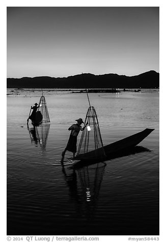 Intha fishermen carrying lanterns at dusk. Inle Lake, Myanmar (black and white)