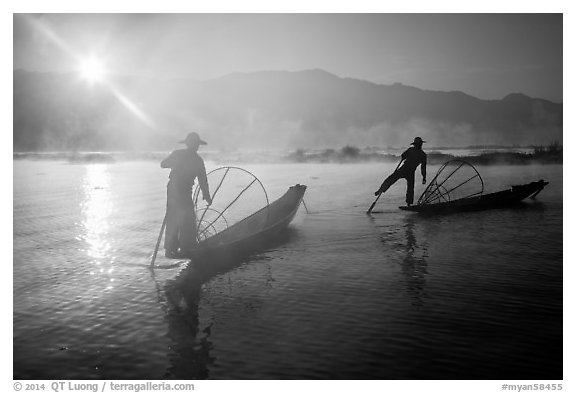 Sun piercing mist behind Intha fishermen. Inle Lake, Myanmar (black and white)
