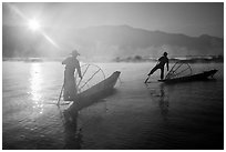 Sun piercing mist behind Intha fishermen. Inle Lake, Myanmar ( black and white)