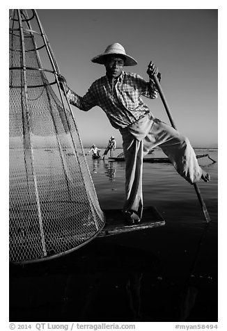 Intha fisherman prepares to release conical basket. Inle Lake, Myanmar (black and white)