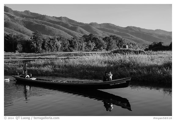 Woman riding with child in front of boat in Maing Thauk Village. Inle Lake, Myanmar (black and white)