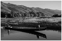 Woman riding with child in front of boat in Maing Thauk Village. Inle Lake, Myanmar ( black and white)