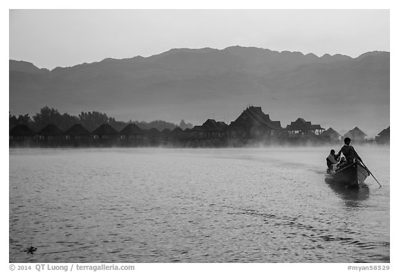 Boat leaving resort in dawn mist. Inle Lake, Myanmar (black and white)