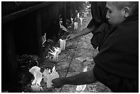 Monks lighting candles. Kyaiktiyo, Myanmar ( black and white)