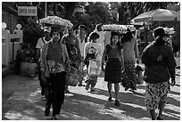 Women walk with platers of food on their heads. Kyaiktiyo, Myanmar ( black and white)