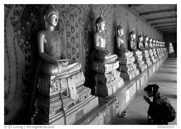 Woman worships a buddha image, Wat Arun. Bangkok, Thailand (black and white)