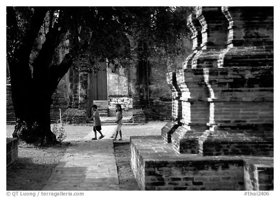 Children walk among ruins of the King Narai's palace. Lopburi, Thailand (black and white)