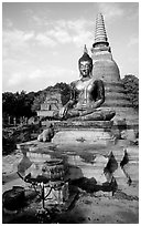 Classic sitting Buddha image and tiered, bell-shaped chedi. Sukothai, Thailand (black and white)