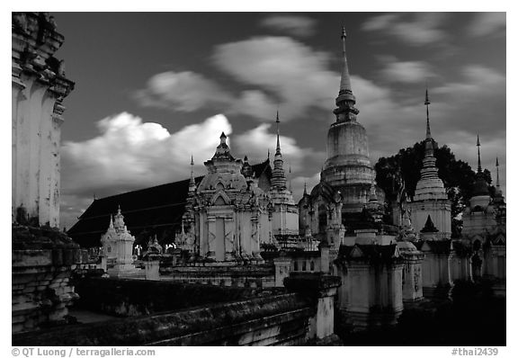 Chedis in blue light with bright clouds, Wat Suan Dok, dusk. Chiang Mai, Thailand (black and white)