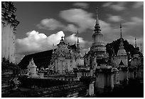Chedis in blue light with bright clouds, Wat Suan Dok, dusk. Chiang Mai, Thailand (black and white)