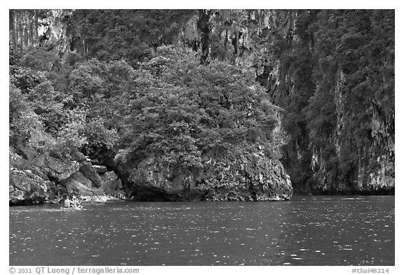 Couple paddling below steep cliffs. Krabi Province, Thailand (black and white)