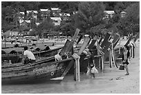 Women returning with shopping bags prepare to board boats, Ko Phi Phi. Krabi Province, Thailand ( black and white)