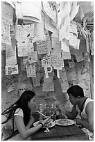Couple eating Pad Thai below notes of praise left by customers, Ko Phi Phi. Krabi Province, Thailand (black and white)