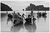 Man stepping on boats, Ao Lo Dalam, Ko Phi-Phi Don. Krabi Province, Thailand ( black and white)