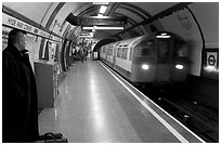 Man waiting for approaching train at Hyde Park subway station. London, England, United Kingdom (black and white)