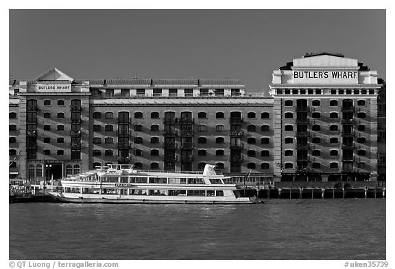 Butler Wharf and tour boat on the Thames. London, England, United Kingdom (black and white)