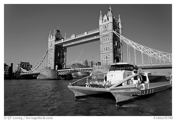 Fast catamaran cruising the Thames, with Tower Bridge in the background. London, England, United Kingdom