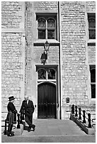 Yeoman Warder talking with man in suit in front of the Jewel House, Tower of London. London, England, United Kingdom (black and white)