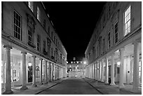 Street bordered by colonades at night. Bath, Somerset, England, United Kingdom (black and white)