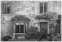 Stone house facade with flowers, Castle Combe. Wiltshire, England, United Kingdom ( black and white)
