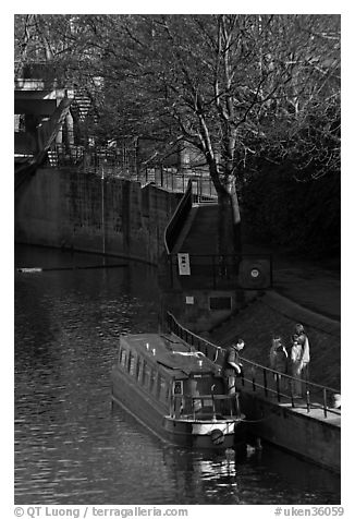 Family stepping out of houseboat onto quay. Bath, Somerset, England, United Kingdom (black and white)