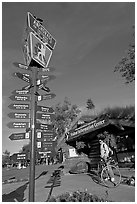 Sign Air Crossroads of the World, man on bicycle in front of visitor center. Anchorage, Alaska, USA ( black and white)