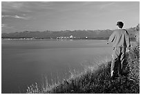 Man walking on the edge of Knik Arm in Earthquake Park, sunset. Anchorage, Alaska, USA ( black and white)