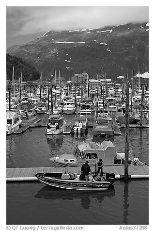 Small boat loaded at pier, harbor, and mountains. Whittier, Alaska, USA