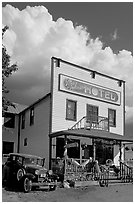 Ma Johnson hotel with classic car parked by, afternoon. McCarthy, Alaska, USA (black and white)