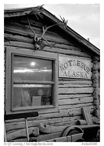 Log cabin with caribou antlers and sun reflected in window. Kotzebue, North Western Alaska, USA (black and white)