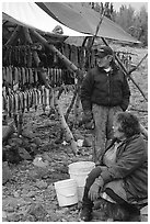 Inupiaq Eskimo man and woman next to fish hung for drying, Ambler. North Western Alaska, USA (black and white)