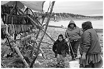 Inupiaq Eskimo family with stand of dried fish, Ambler. North Western Alaska, USA (black and white)