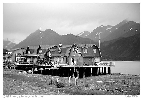 Stilt houses on the Spit, Kenai Mountains in the backgound. Homer, Alaska, USA