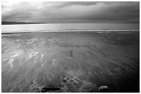 Sand patterns and stormy skies on the Bay. Homer, Alaska, USA ( black and white)