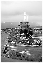 Retired fishing boat with a pile of marine gear on the Spit. Homer, Alaska, USA ( black and white)