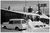 Old truck parked next to lodge in winter. Alaska, USA ( black and white)