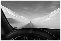 Road in wintry landscape seen from dashboard indicating -32F temperature. Alaska, USA (black and white)