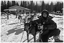 Woman dog musher posing with dog team. Chena Hot Springs, Alaska, USA (black and white)