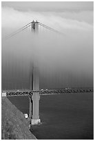 Golden Gate bridge with top covered by fog. San Francisco, California, USA (black and white)