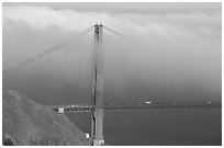 Golden Gate bridge with top covered by fog. San Francisco, California, USA (black and white)