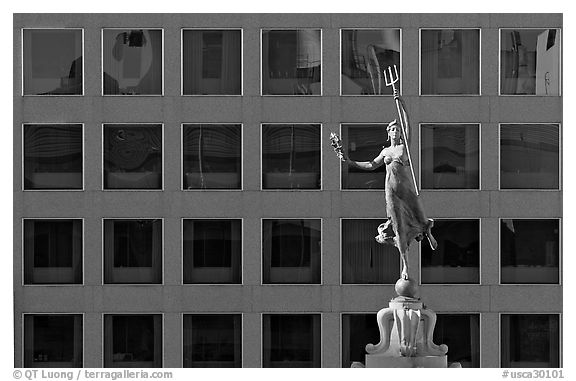Statue on Admiral Dewey memorial column in front of modern building. San Francisco, California, USA (black and white)